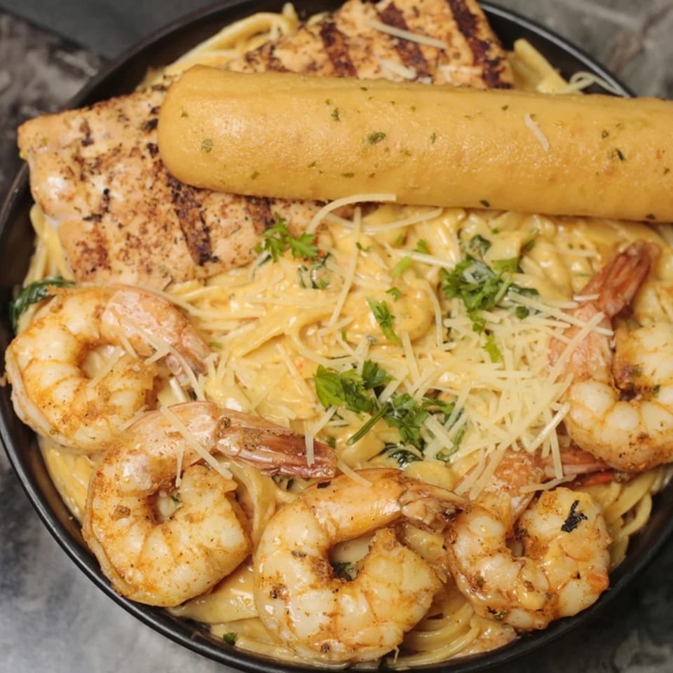 Zodiac Bar & Grill's creamy pasta with grilled chicken, shrimp, and a breadstick.